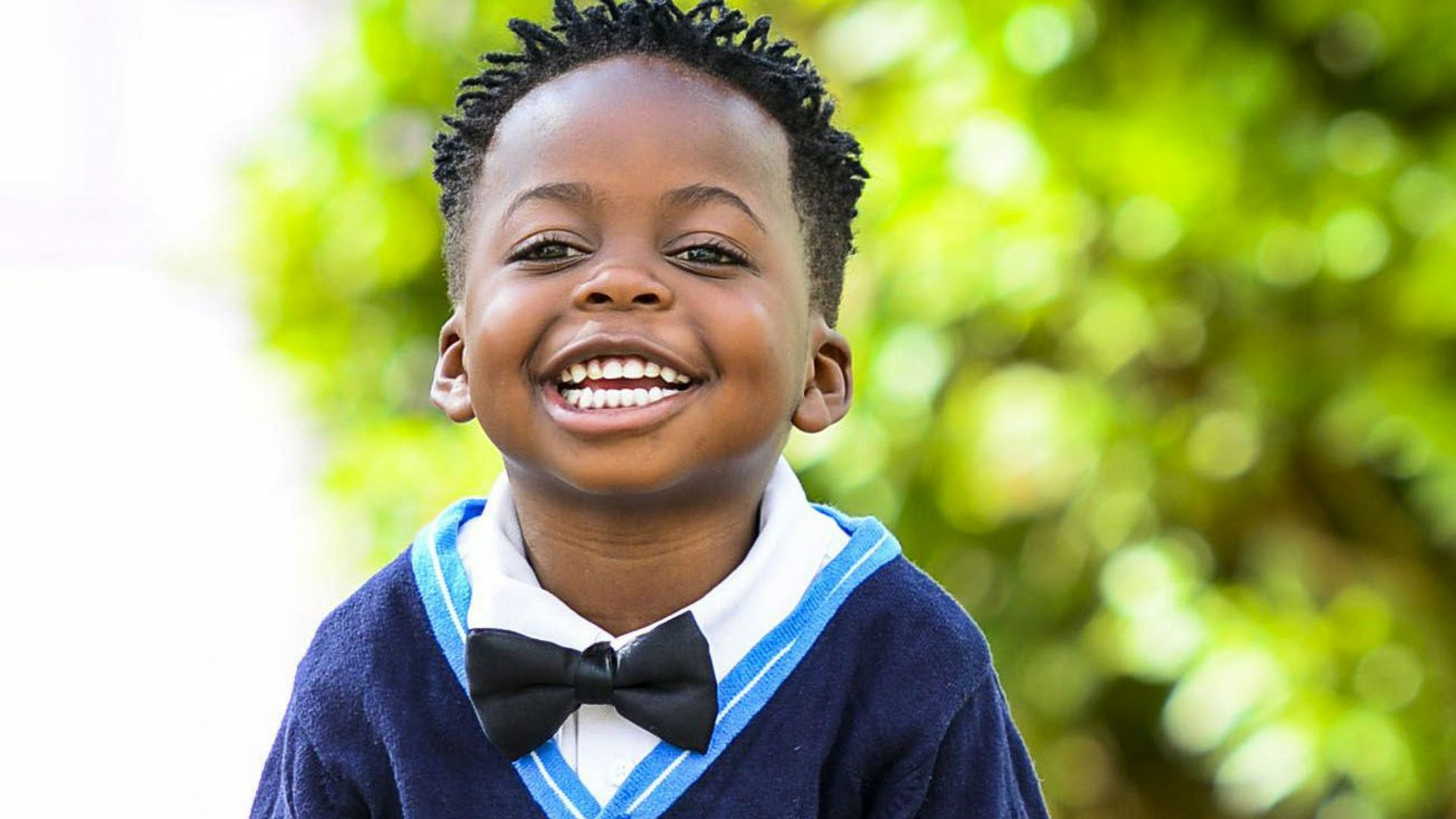 selective focus photo of boy standing on grey pavement