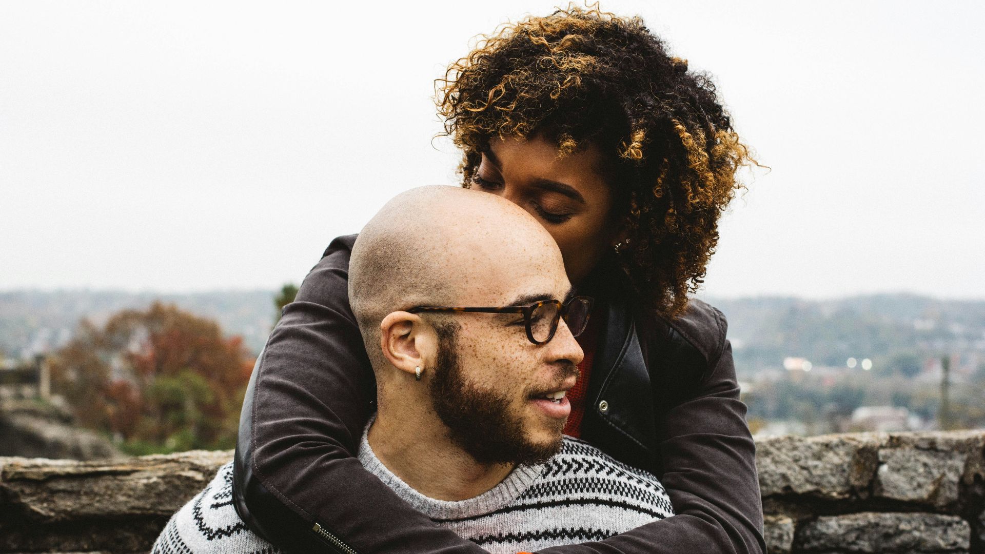 woman kissing man's head