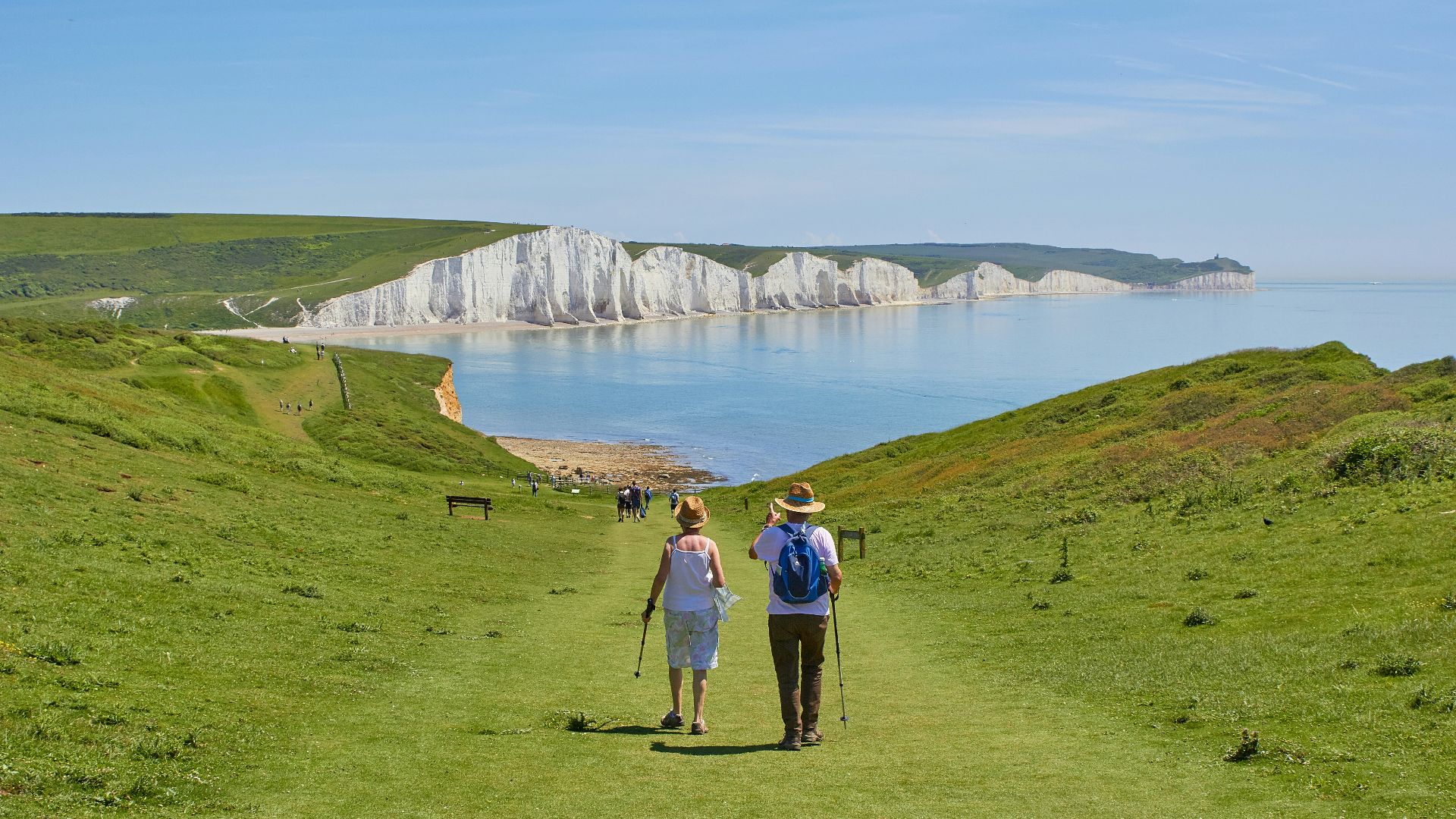 2 men standing on green grass field near body of water during daytime