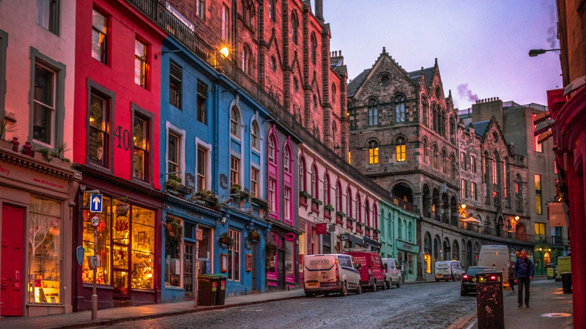 people walking on sidewalk near red concrete building during daytime