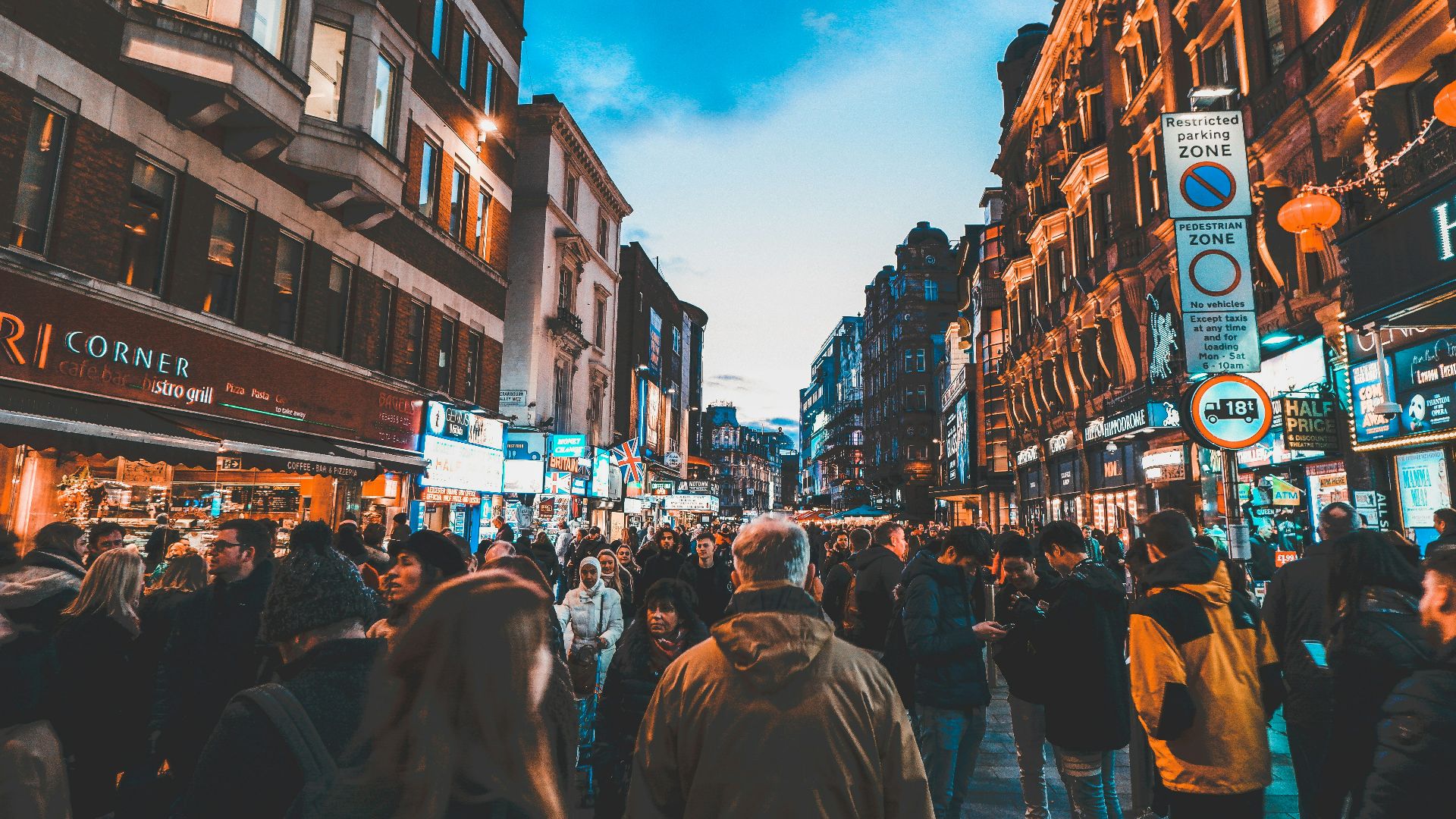 people walking on street between commercial buildings
