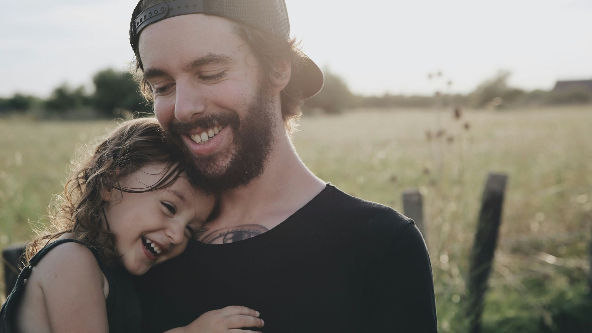 man carrying daughter in black sleeveless top
