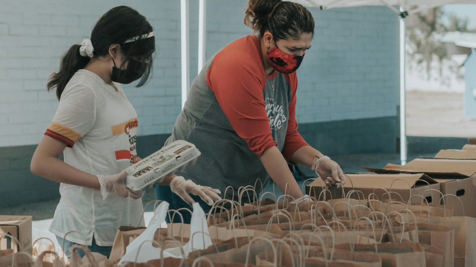 man in red t-shirt holding white plastic bottle