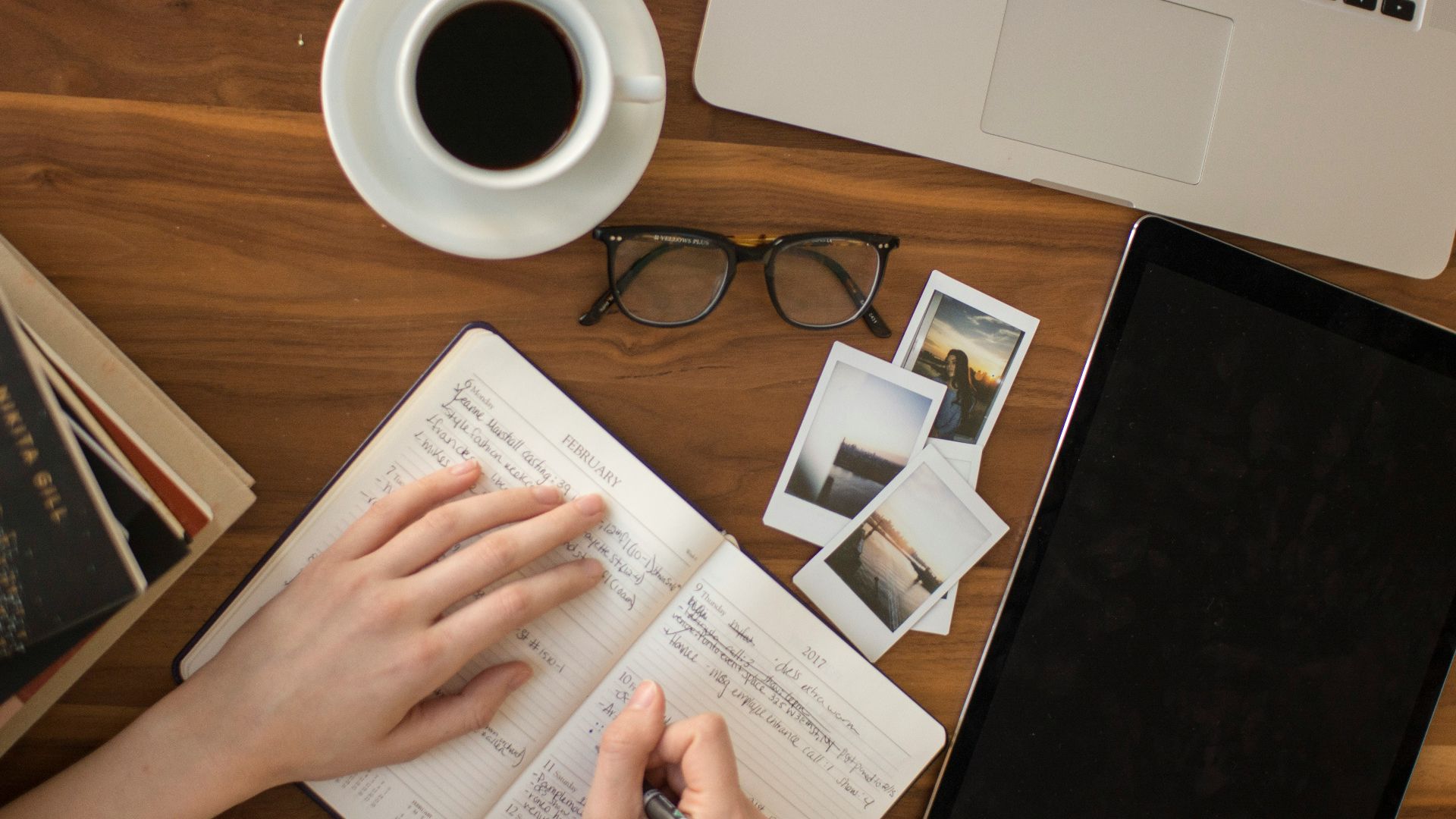 person holding ballpoint pen writing on notebook