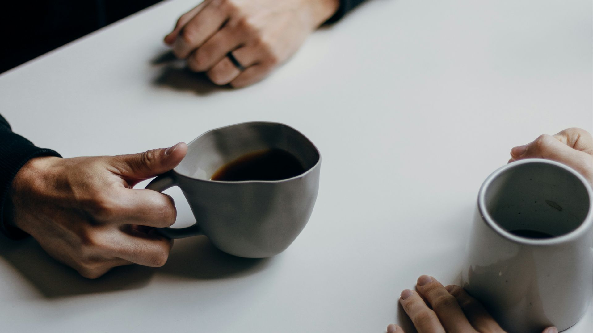 a couple of people sitting at a table with cups of coffee