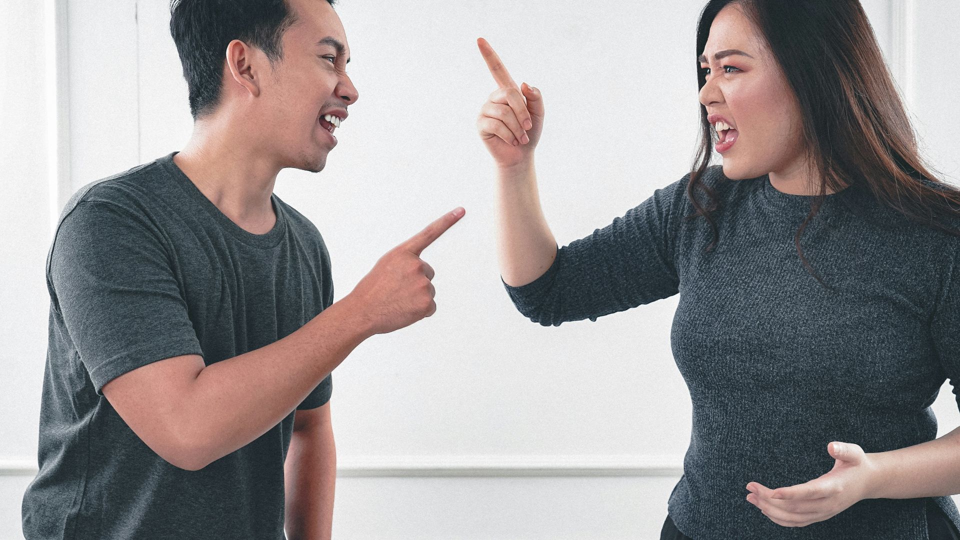 man in gray crew neck long sleeve shirt standing beside woman in black crew neck shirt