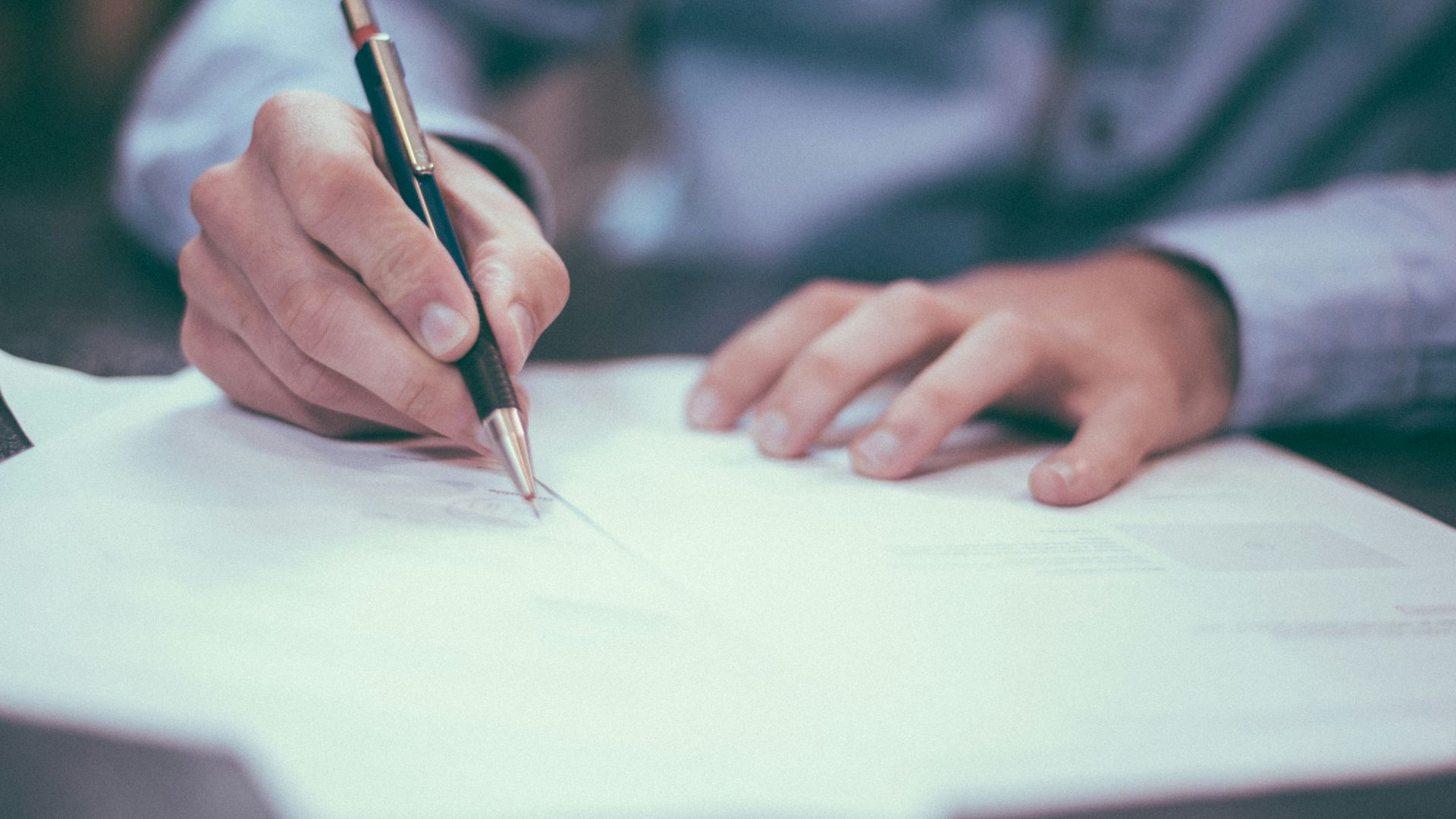 man writing on paper