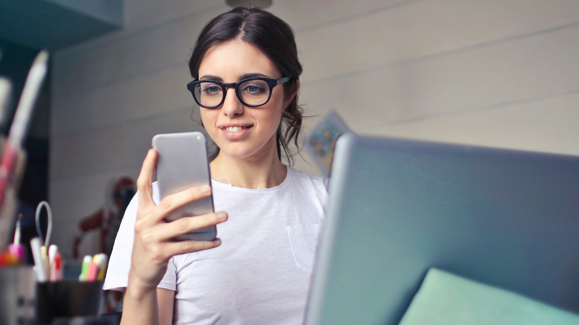 woman in white shirt using smartphone