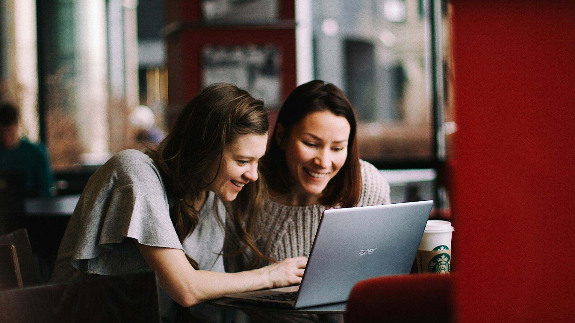 woman in white shirt using macbook