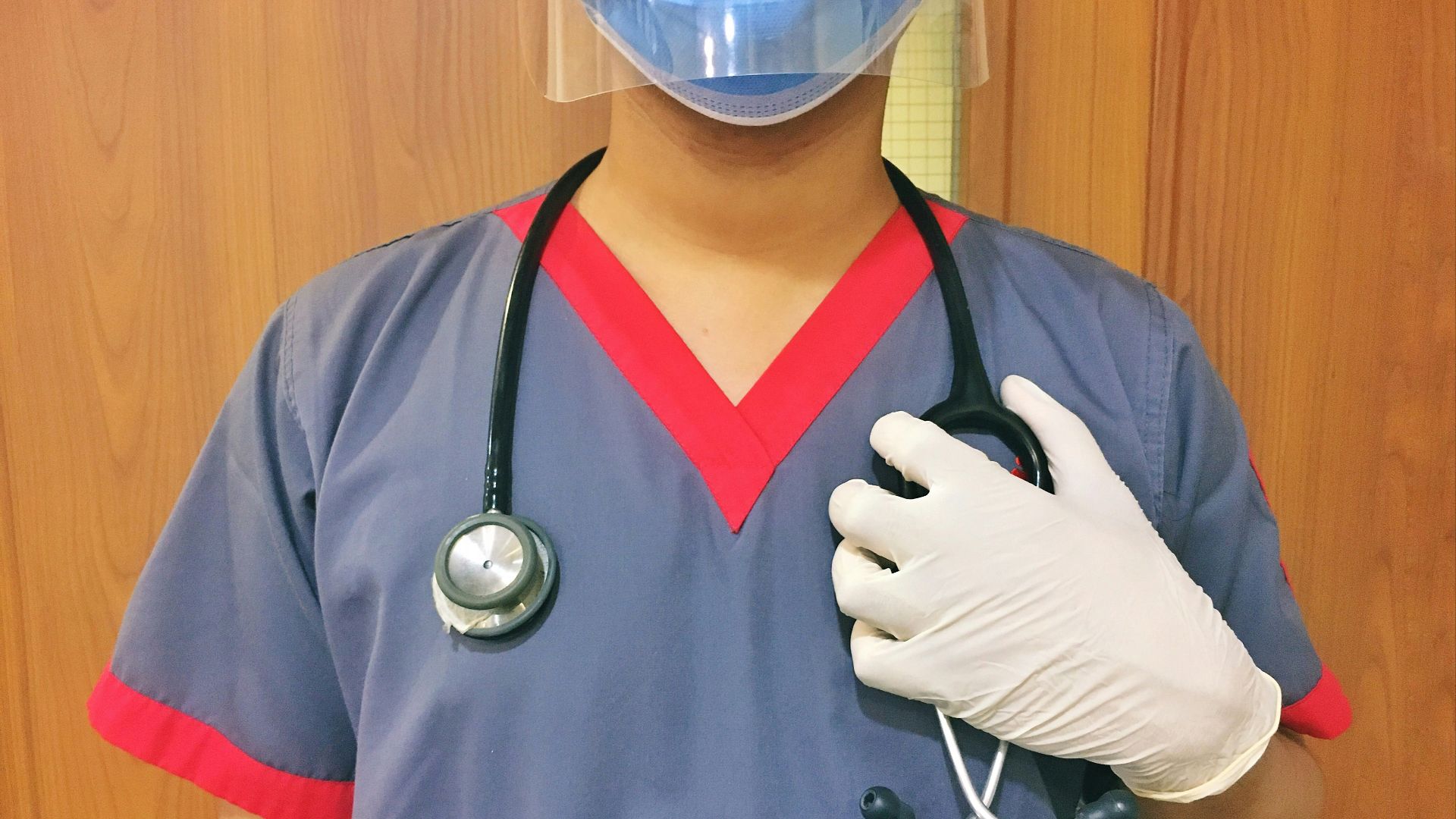 woman in blue scrub suit wearing white mask