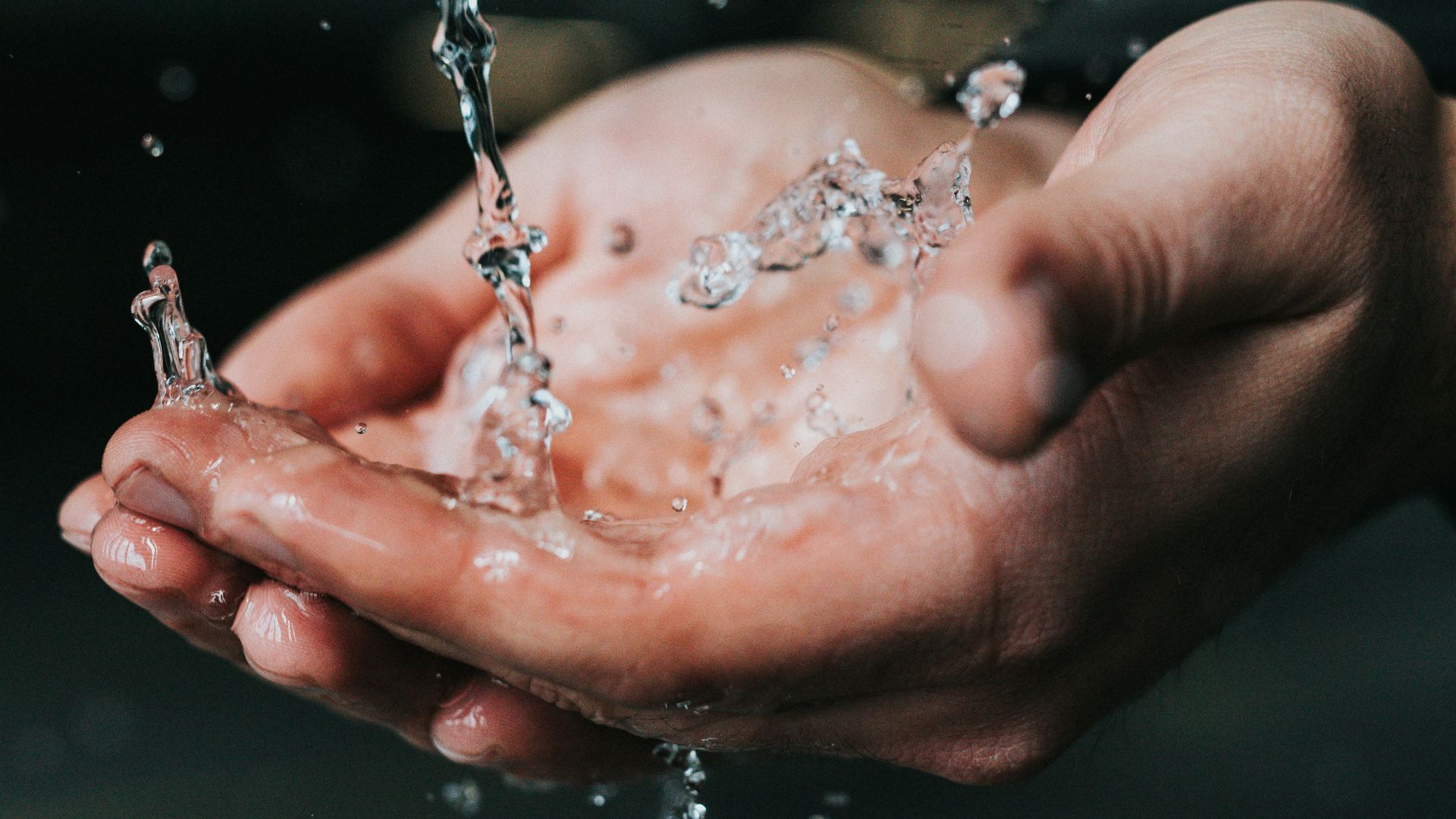 clear liquid pouring on person's hands