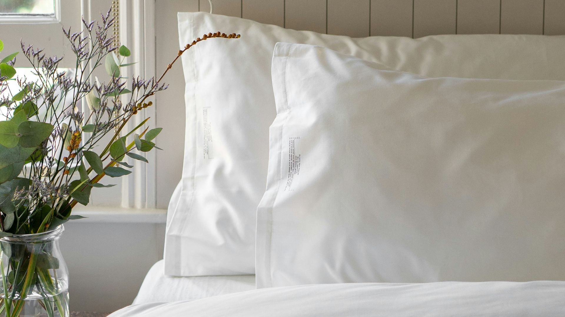 a bed with a white comforter and pillows
