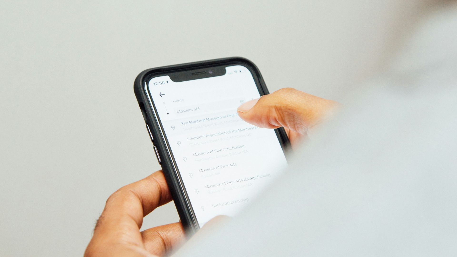 man in white top holding iPhone