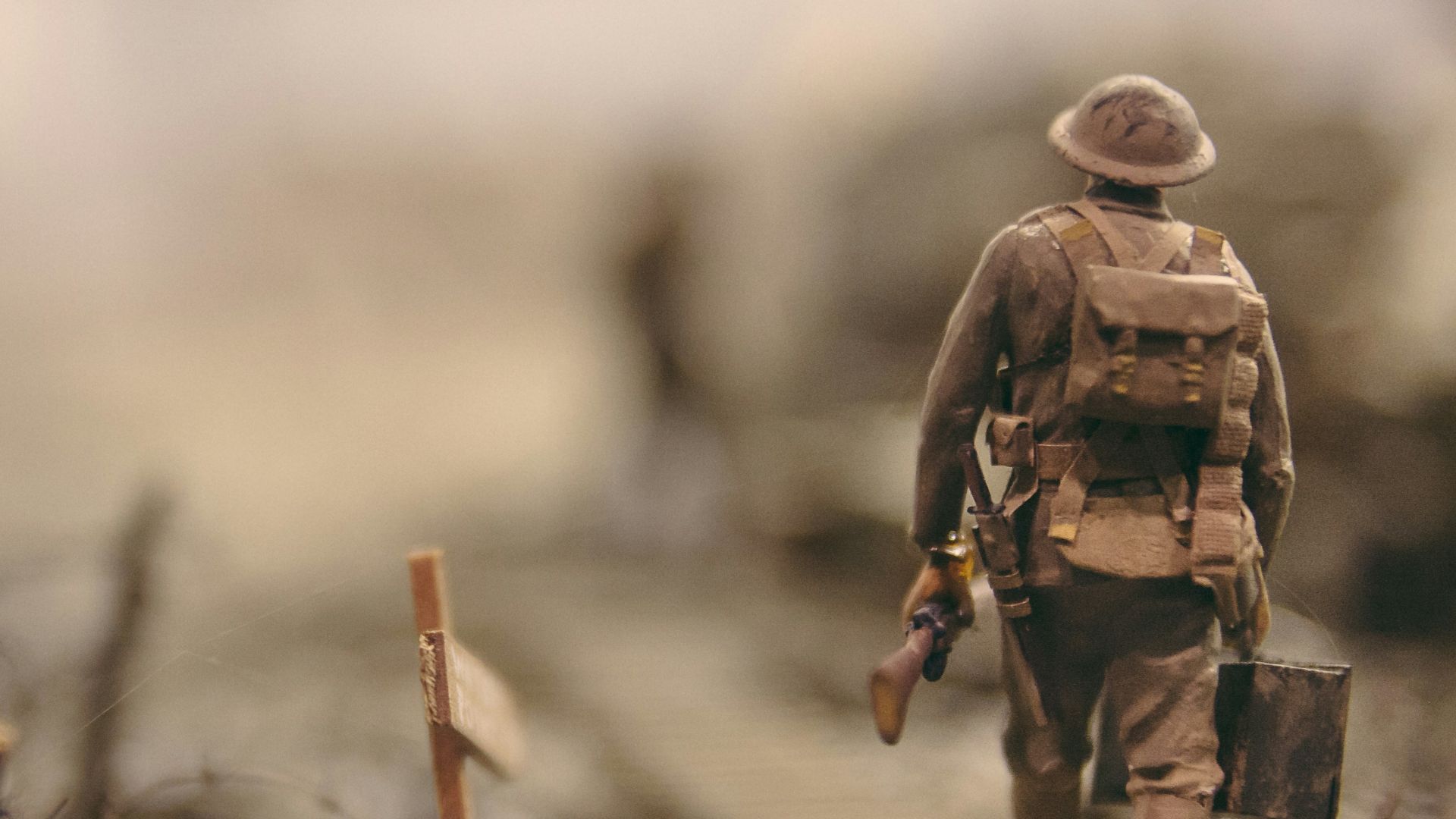 soldier walking on wooden pathway surrounded with barbwire selective focus photography