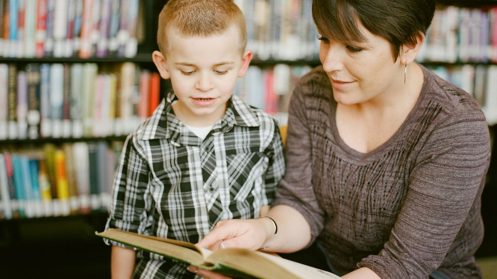 boy in gray sweater beside boy in gray and white plaid dress shirt