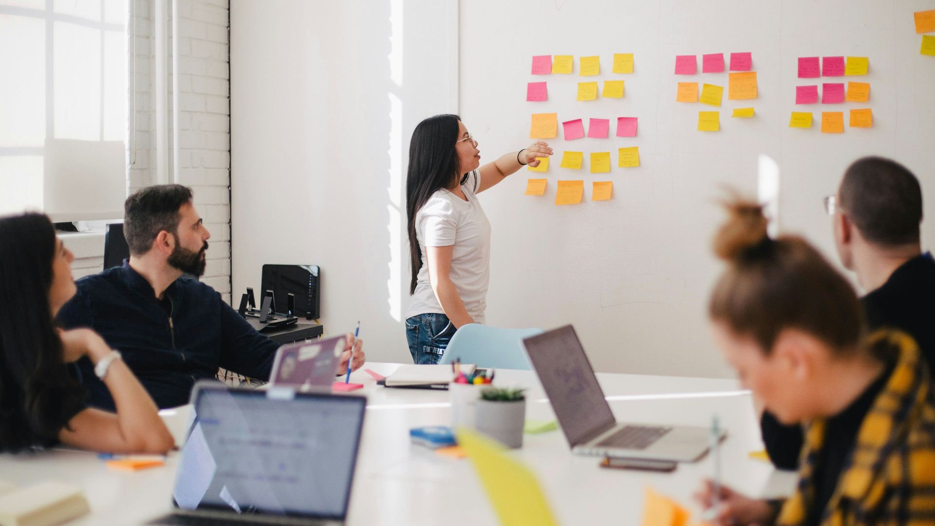 woman placing sticky notes on wall