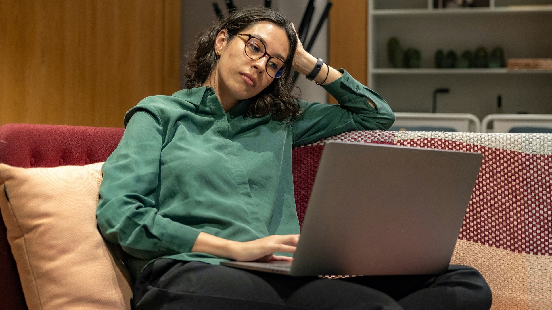a woman sitting on a couch using a laptop computer