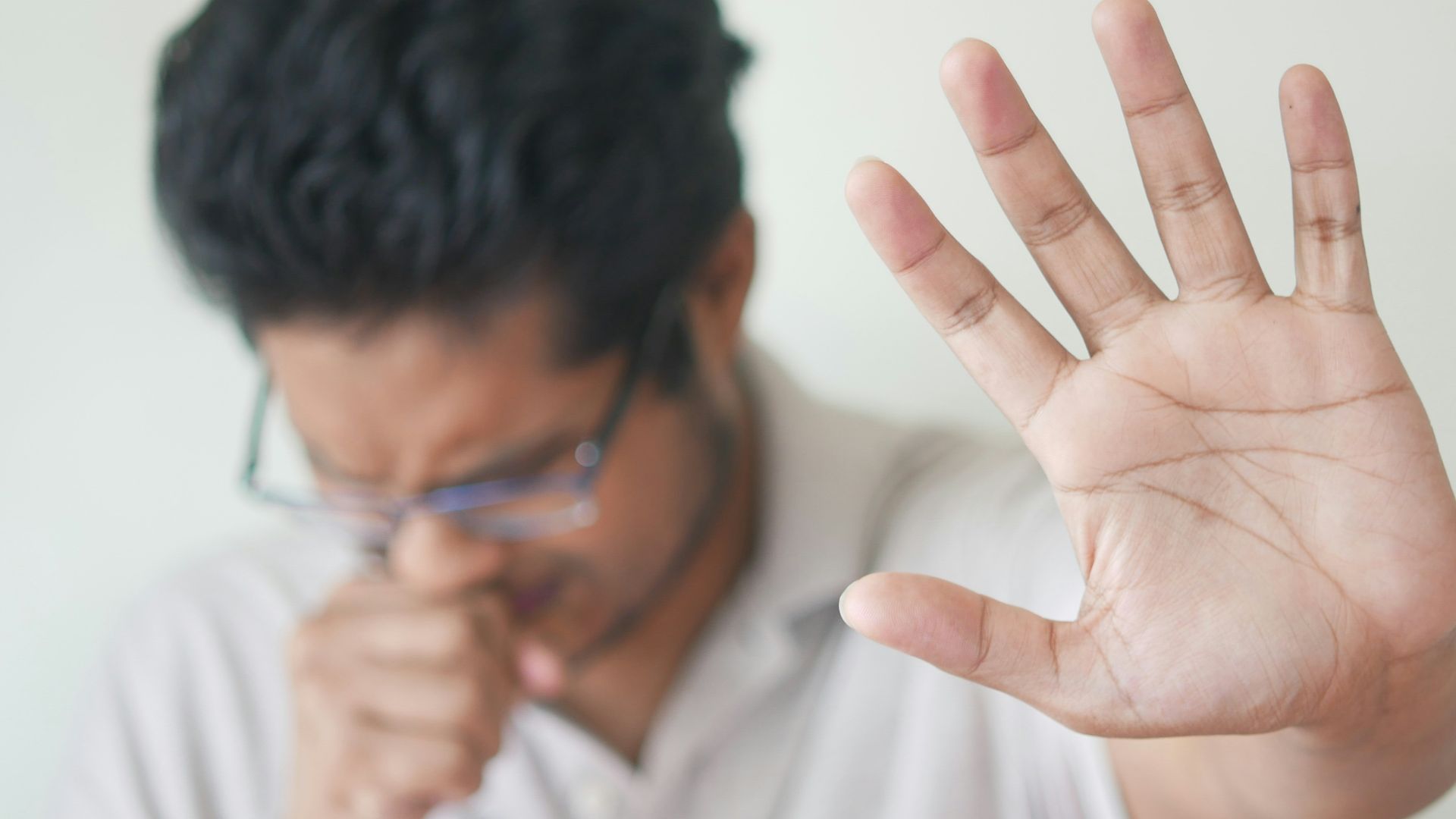 a man holding his hand up in front of his face