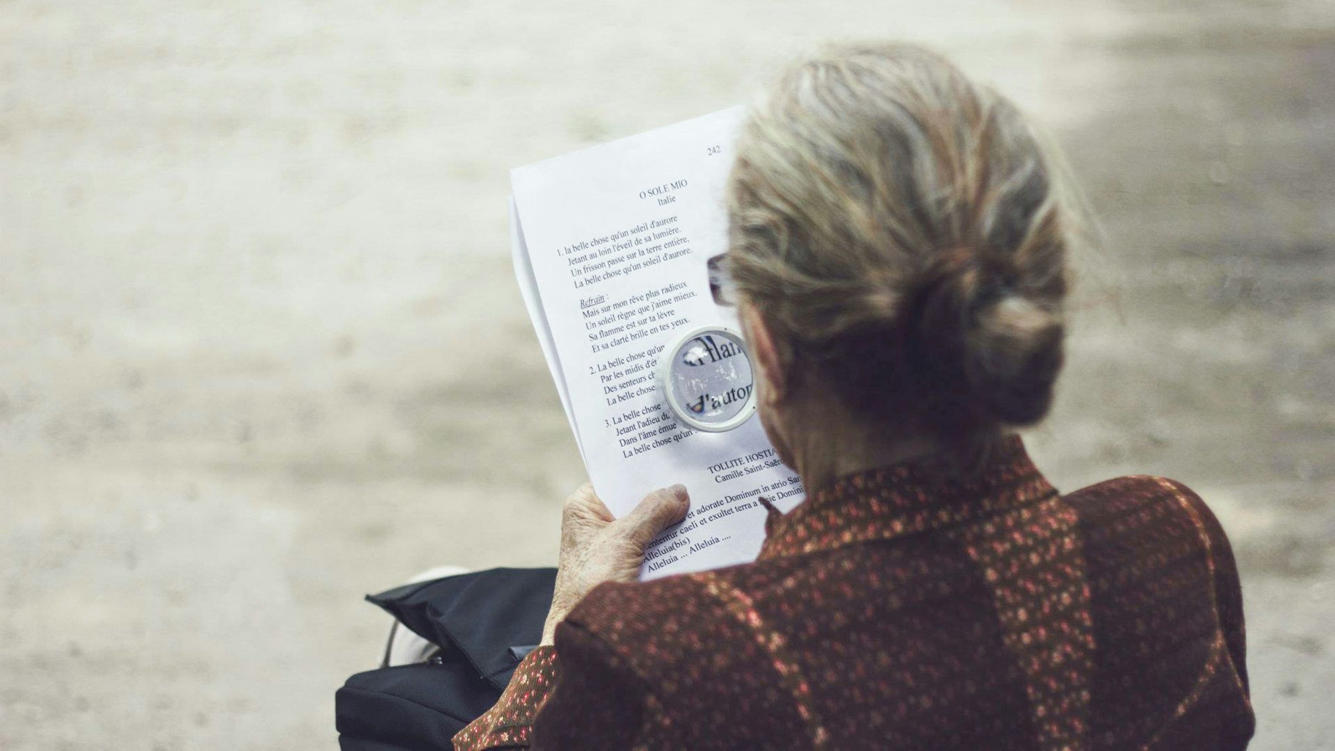 woman in brown top reading paper
