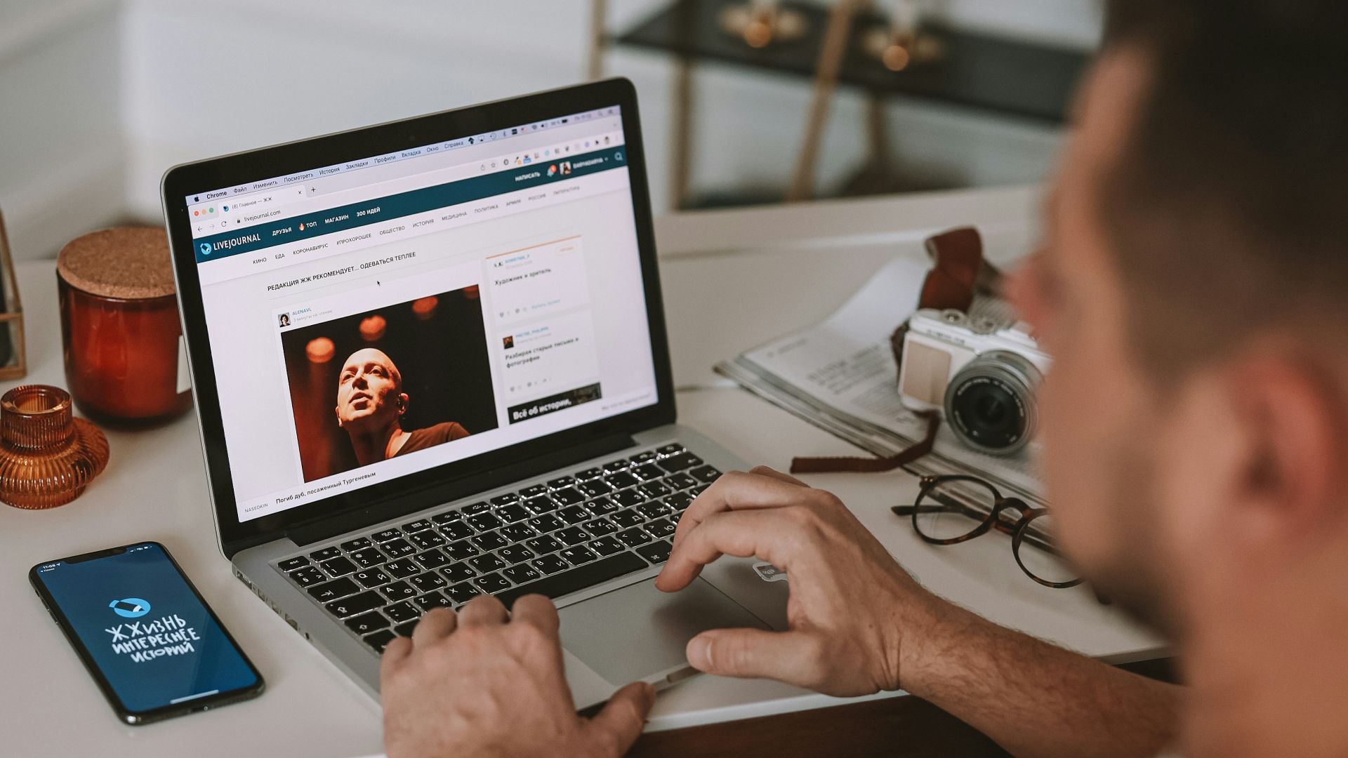 a man sitting at a desk using a laptop computer