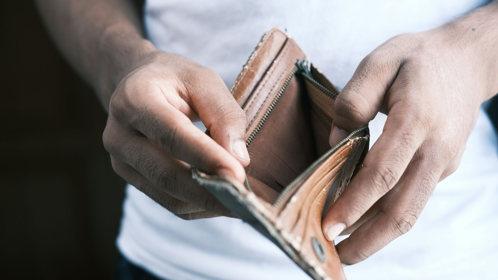 person holding brown leather bifold wallet