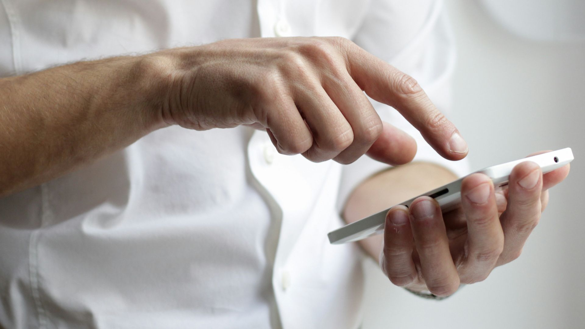 person holding white Android smartphone in white shirt