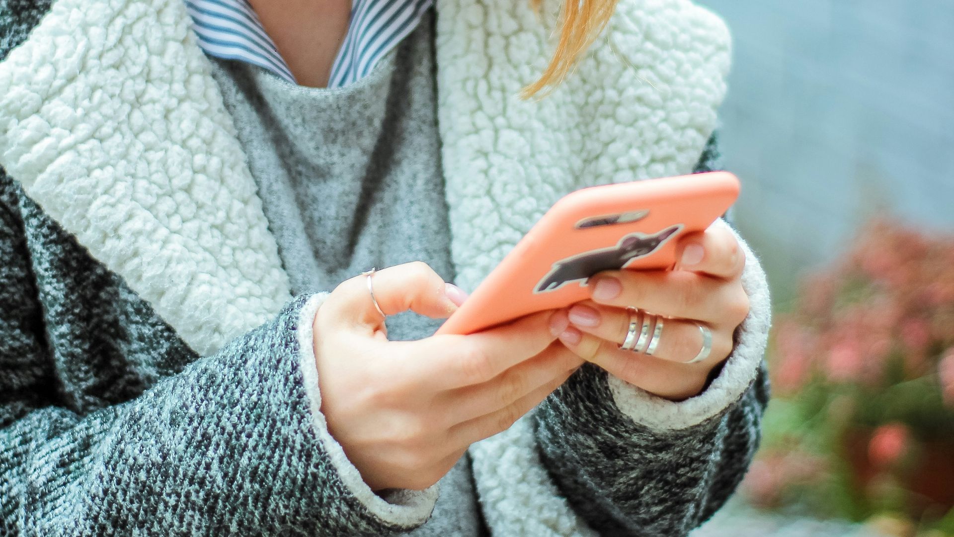 woman smiling while using her phone