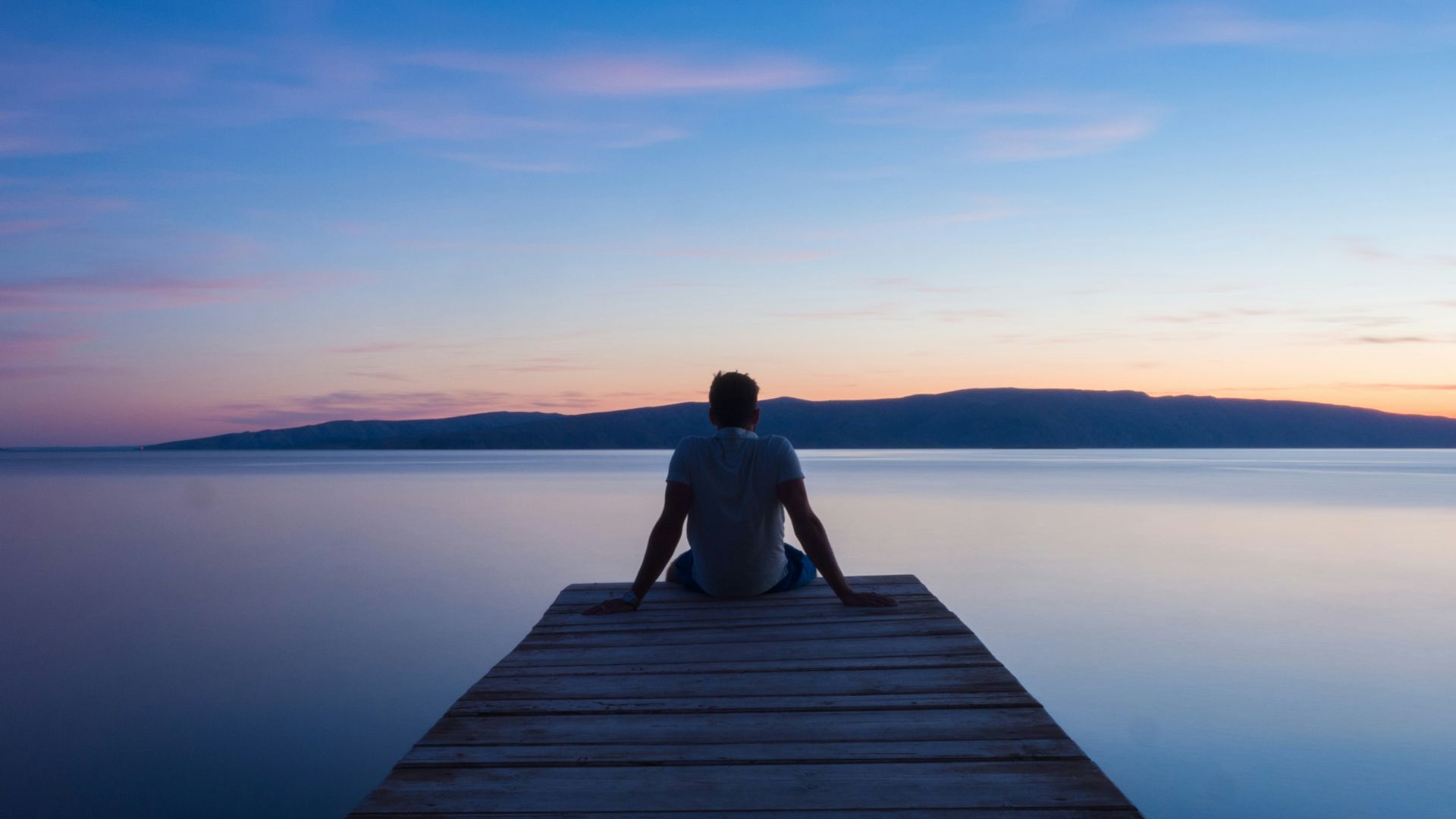 man siting on wooden dock