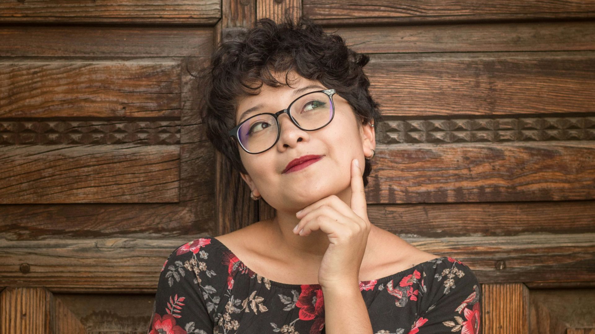 woman leaning against door while holding her cheek