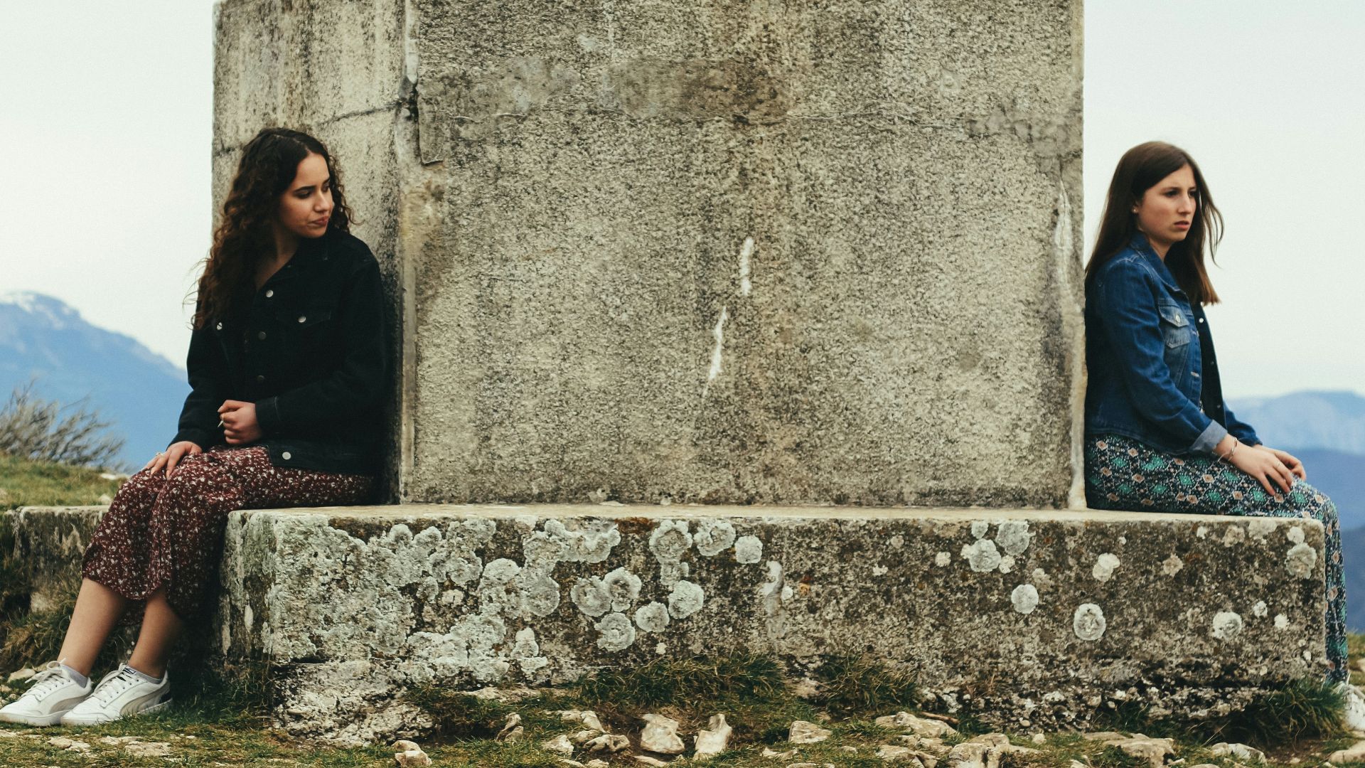 woman in black jacket sitting beside woman in black jacket