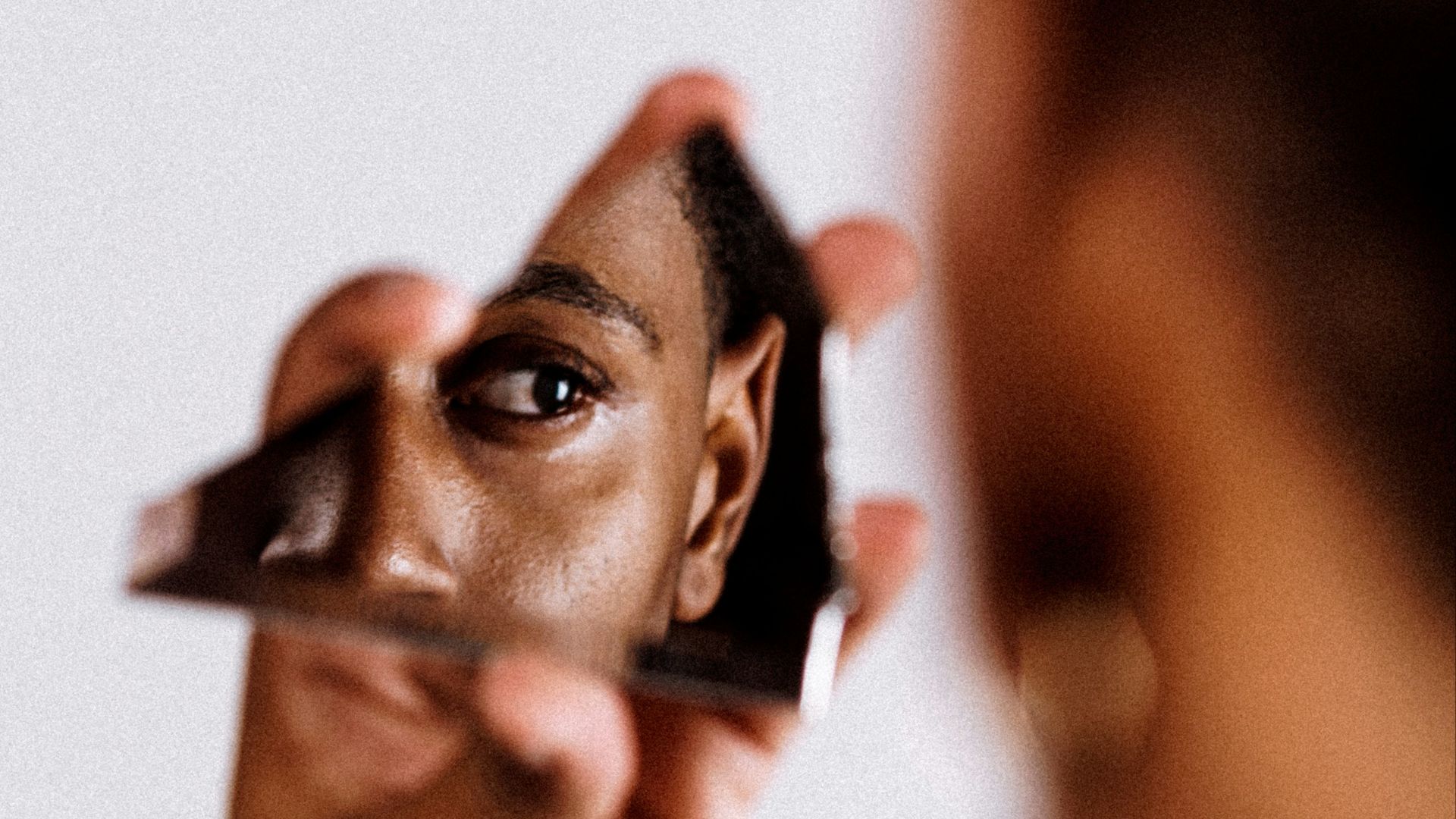 man holding broken mirror