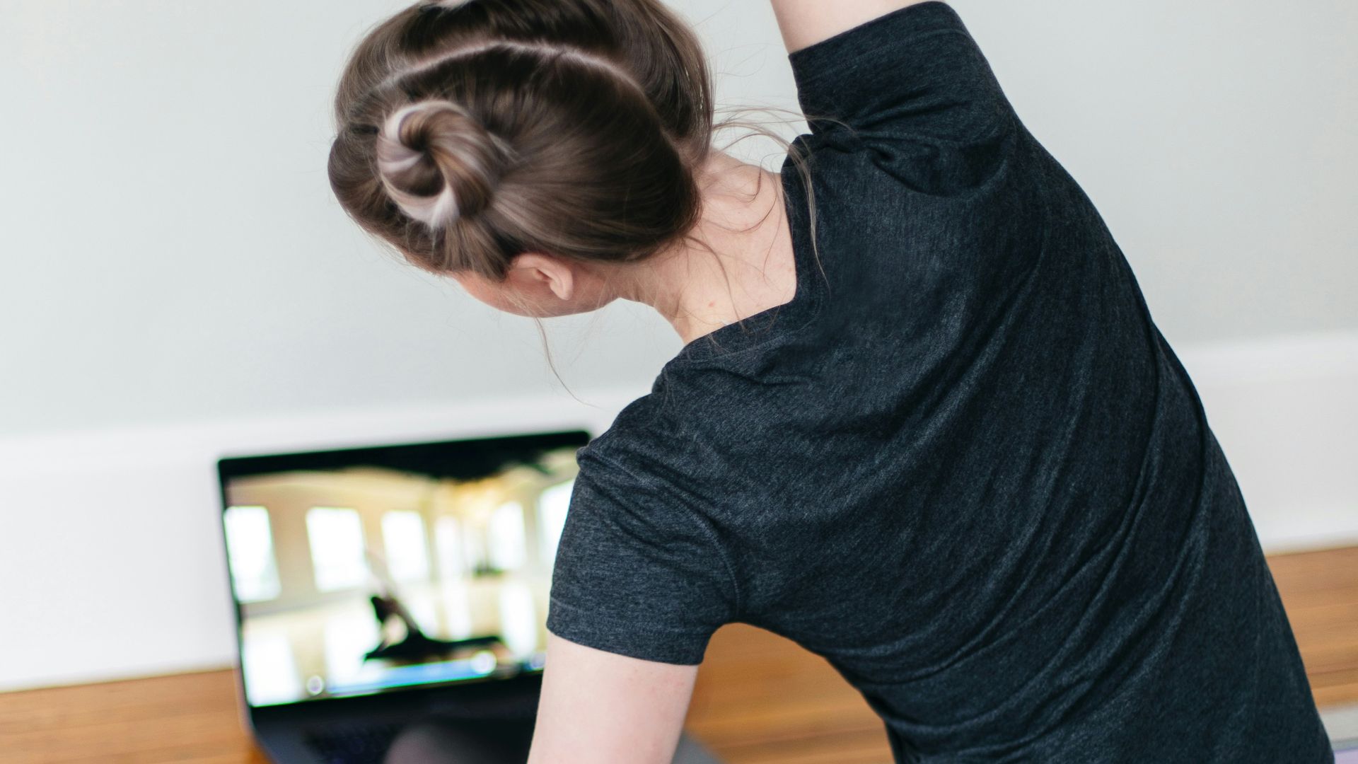 woman in black t-shirt and black pants lying on black yoga mat