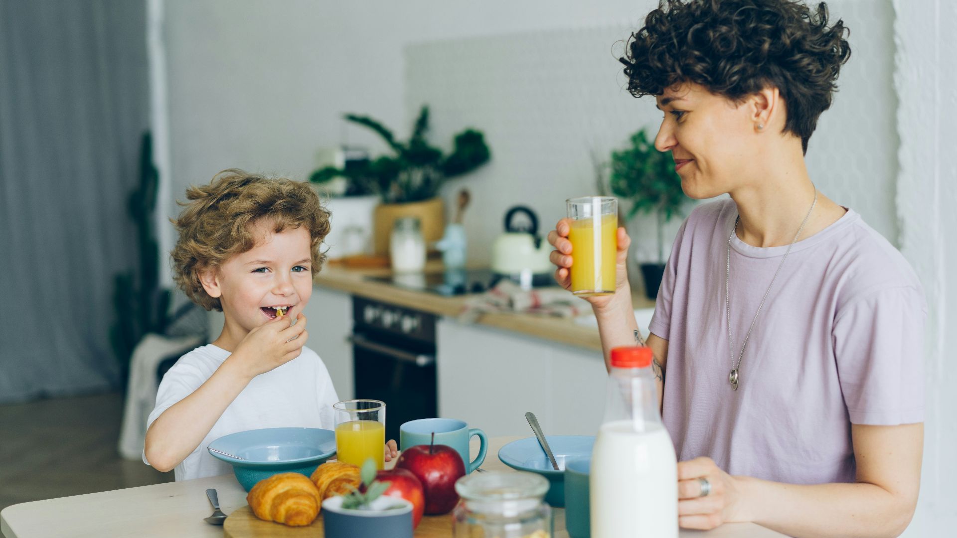 a woman and a child sitting at a kitchen table