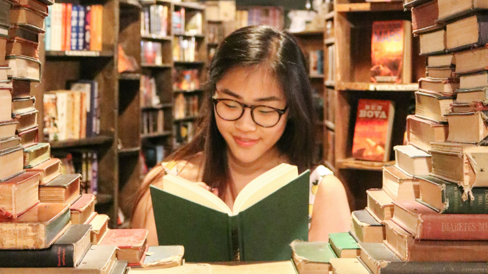 woman in green shirt sitting on books