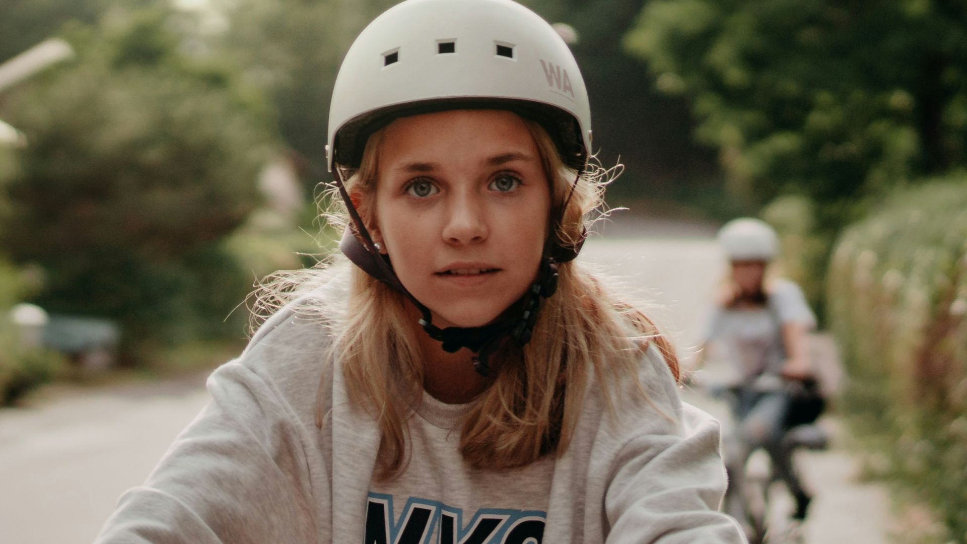 woman in white long sleeve shirt riding bicycle on road during daytime