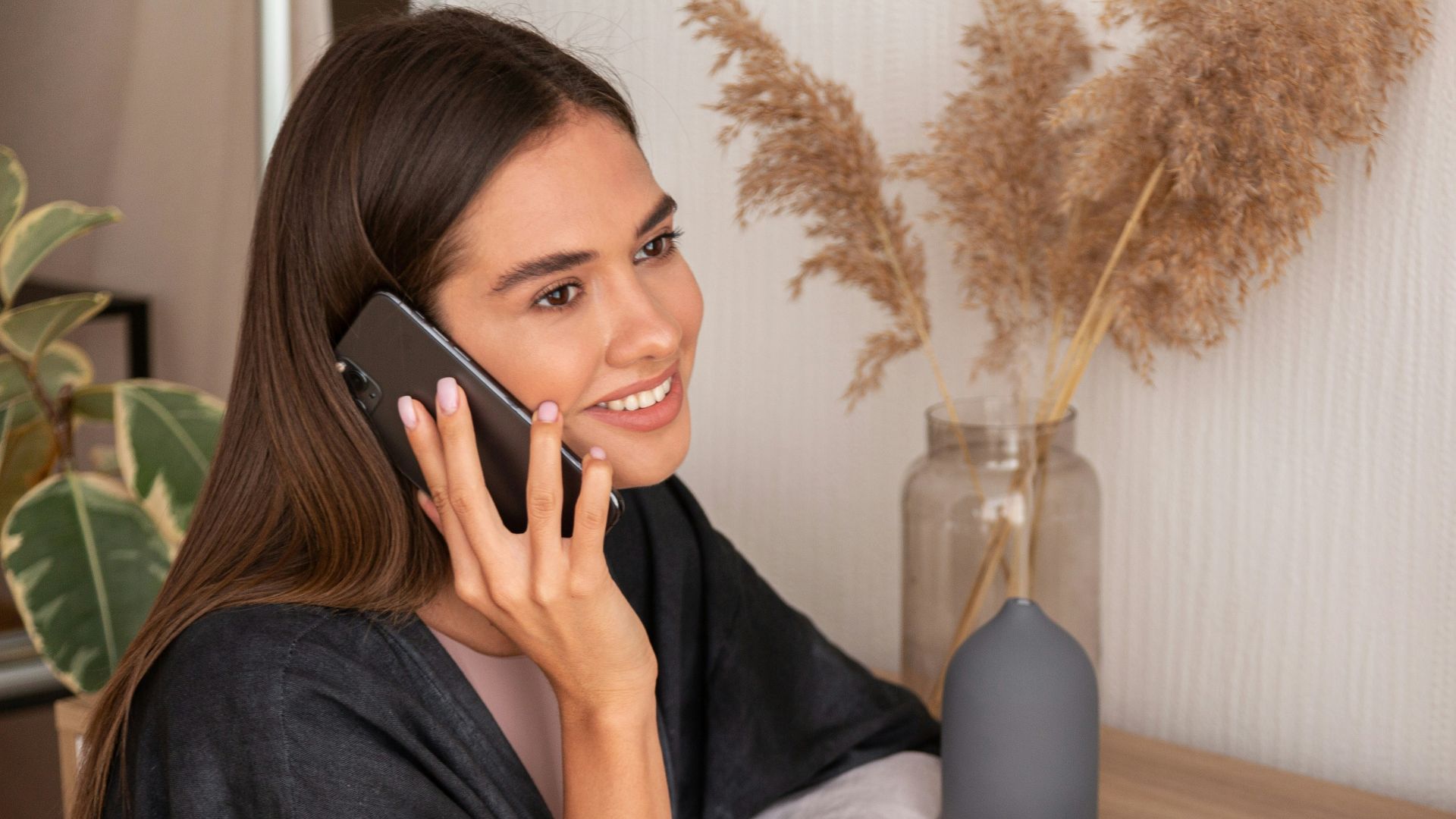 a woman sitting on a counter talking on a cell phone