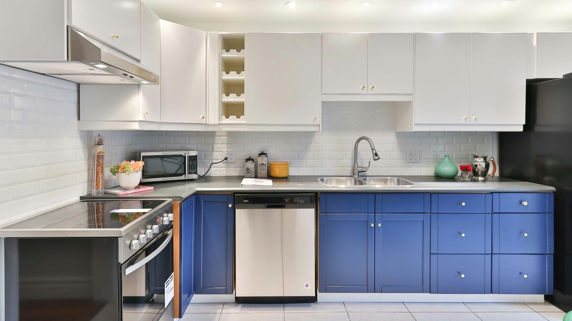 a kitchen with blue cabinets and a black refrigerator