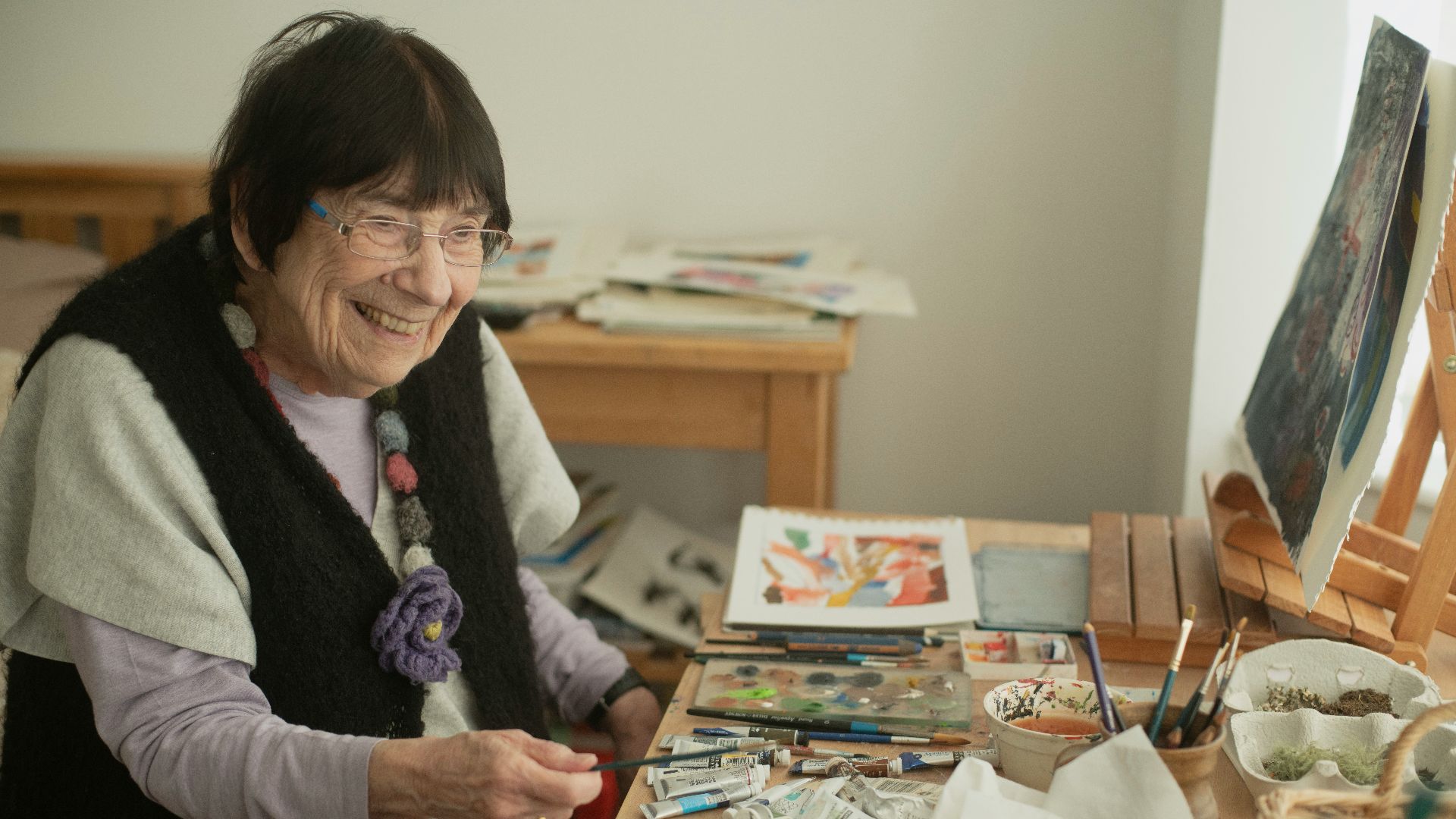 A woman sitting in a chair in front of a wooden table