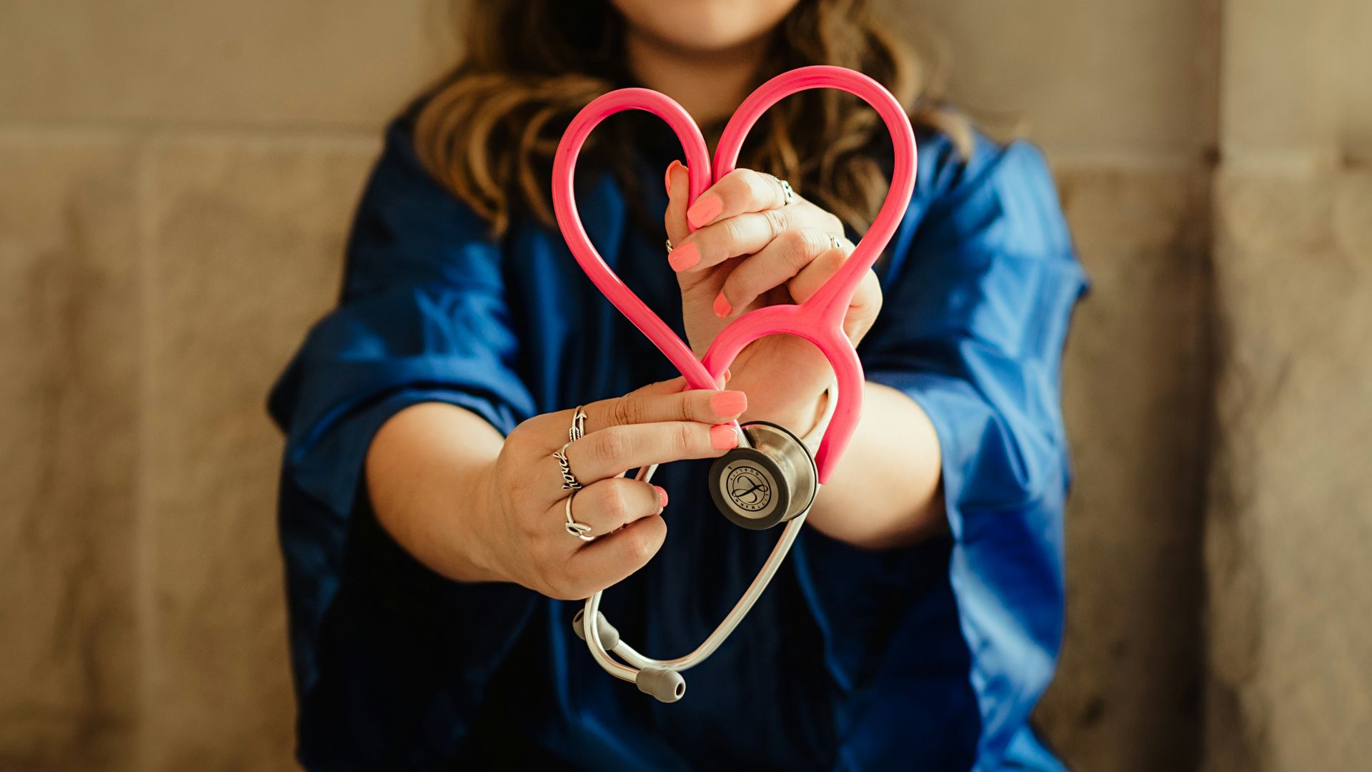 girl in blue jacket holding red and silver ring