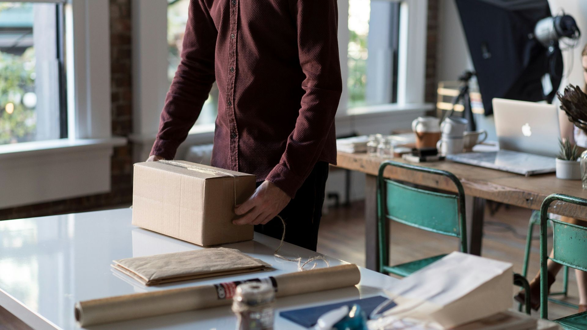 person holding cardboard box on table