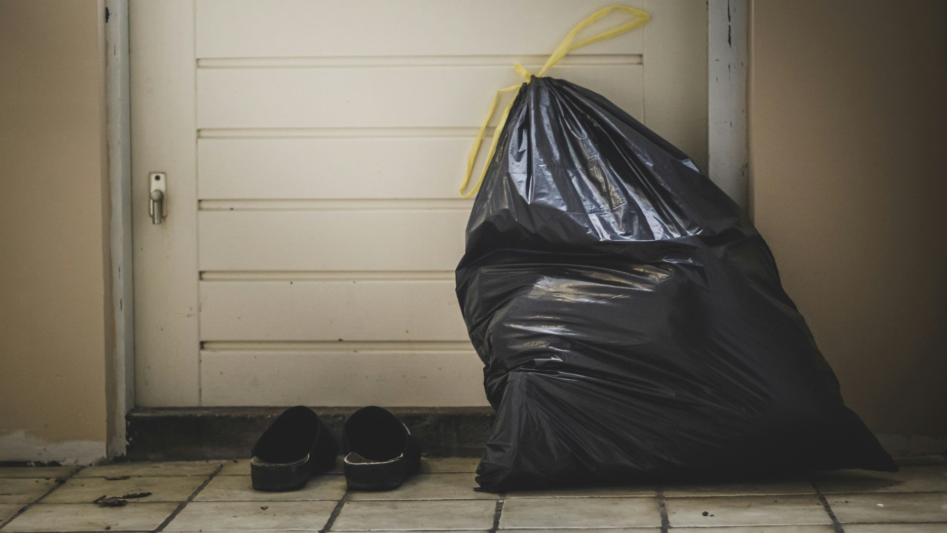 black plastic bag beside white wall