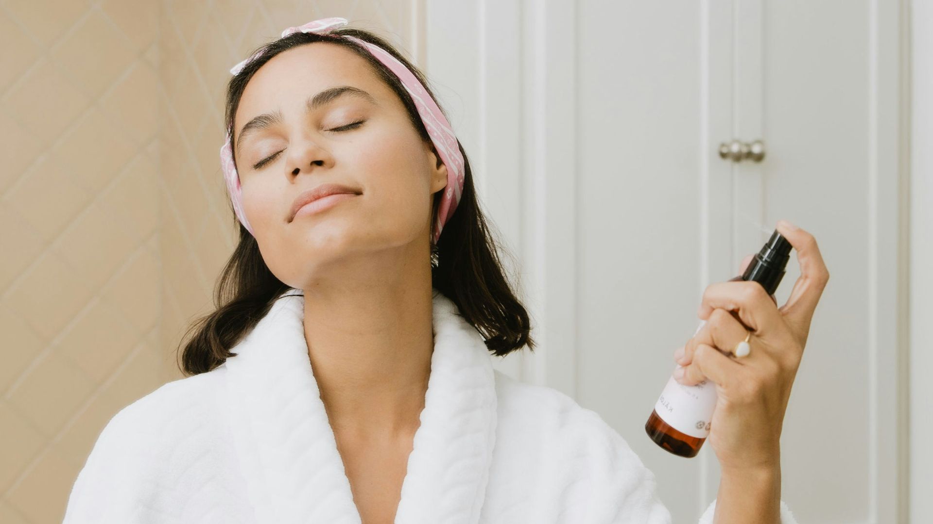 woman in white bathrobe holding smartphone