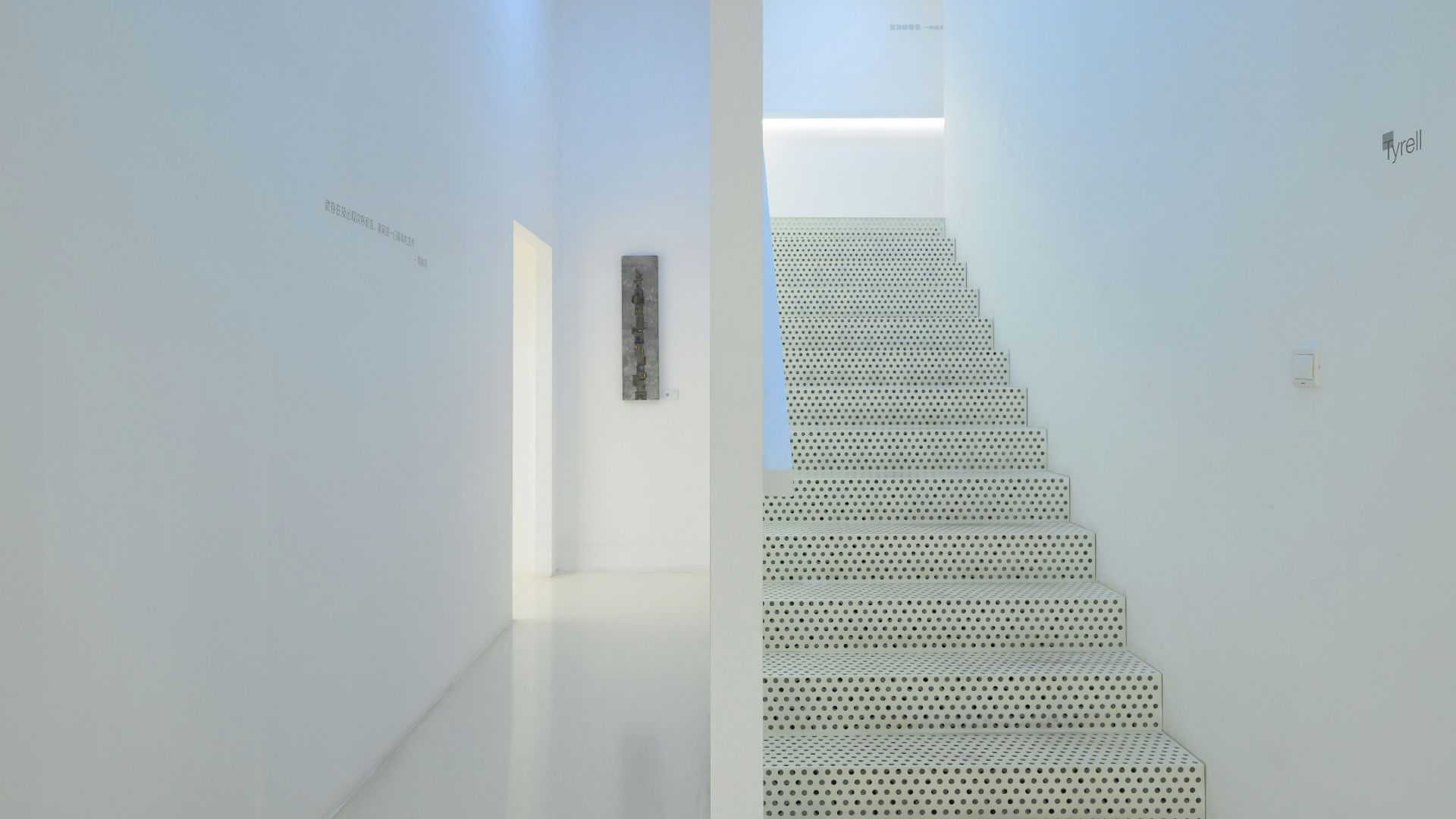 There is a white staircase leading up to the second floor