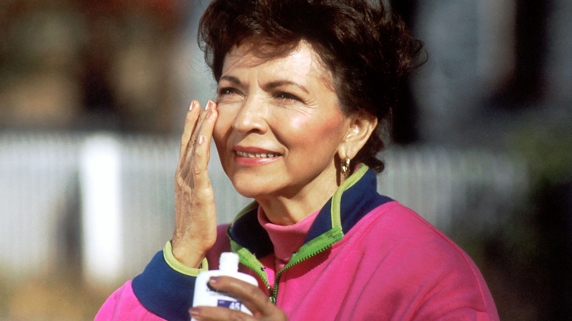 smiling woman in pink and blue shirt