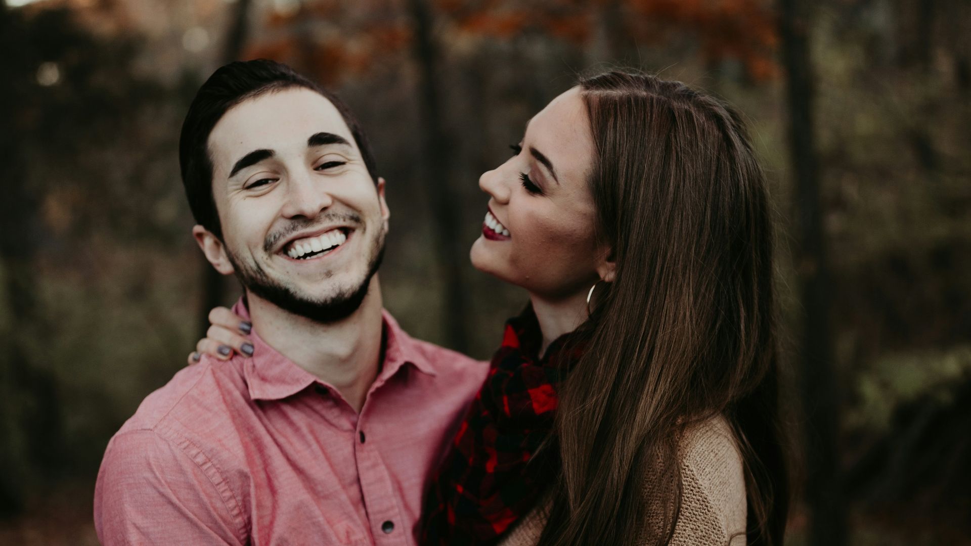 woman hugging man selective focus photography