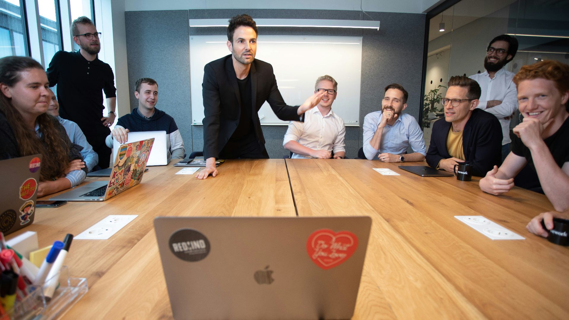 a group of people sitting around a wooden table