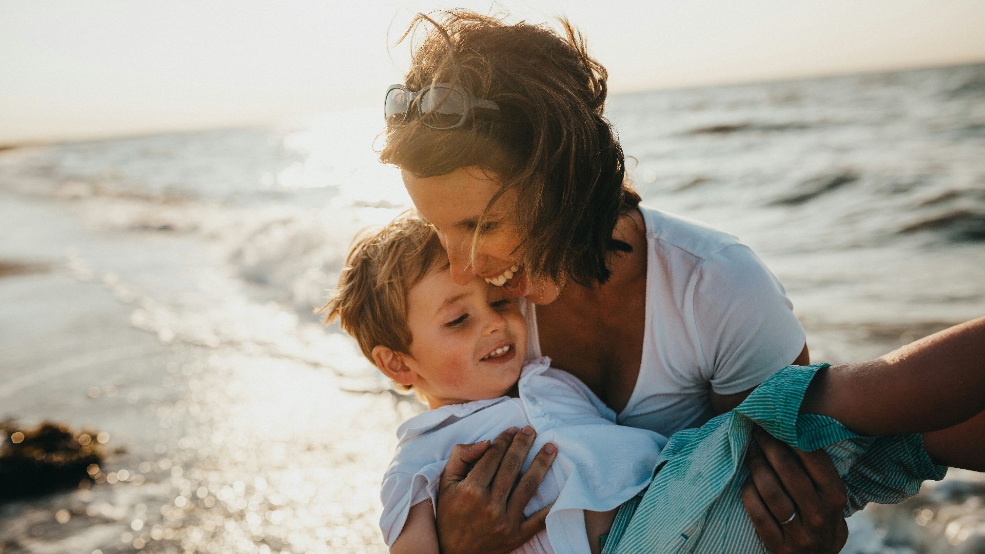 photo of mother and child beside body of water
