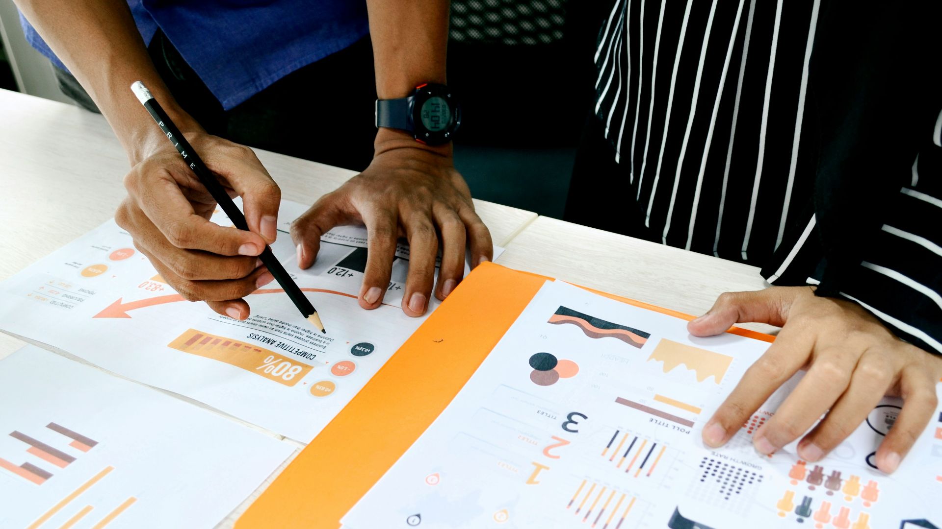 person in blue shirt writing on white paper