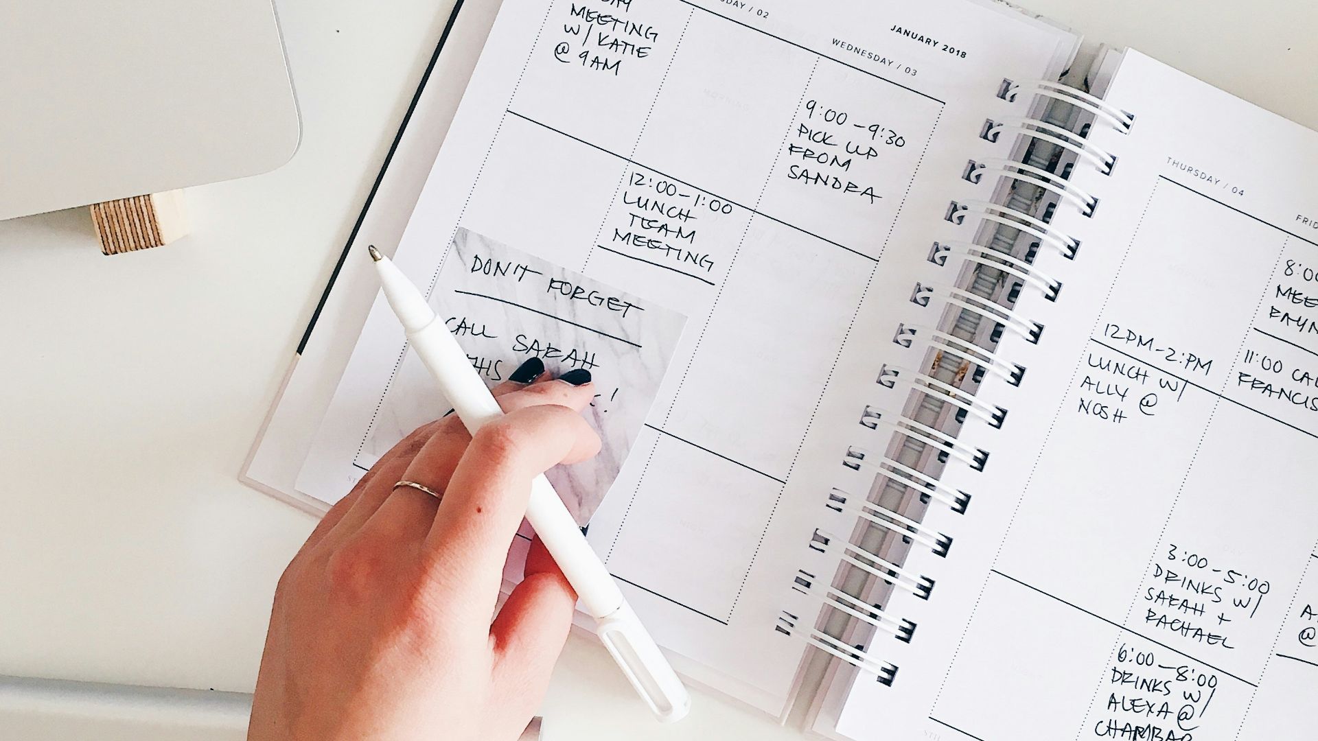 person holding notepad and pen flat lay photography