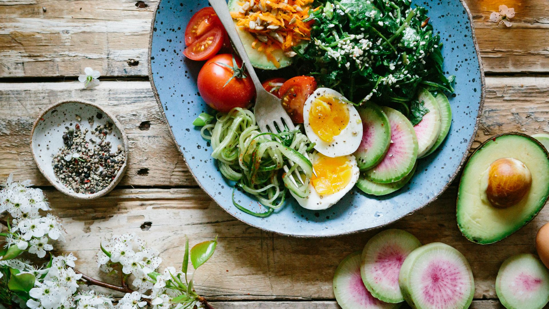 poached egg with vegetables and tomatoes on blue plate